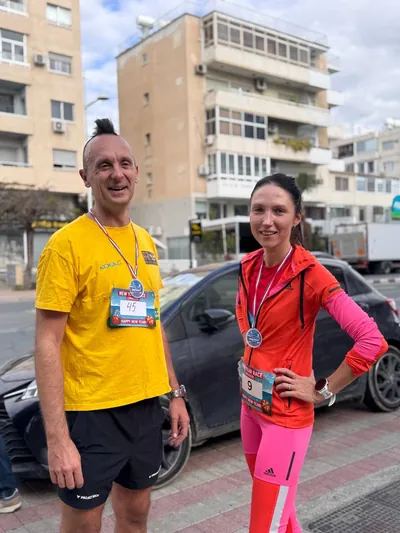 A man and a woman wearing finisher medals after the race.